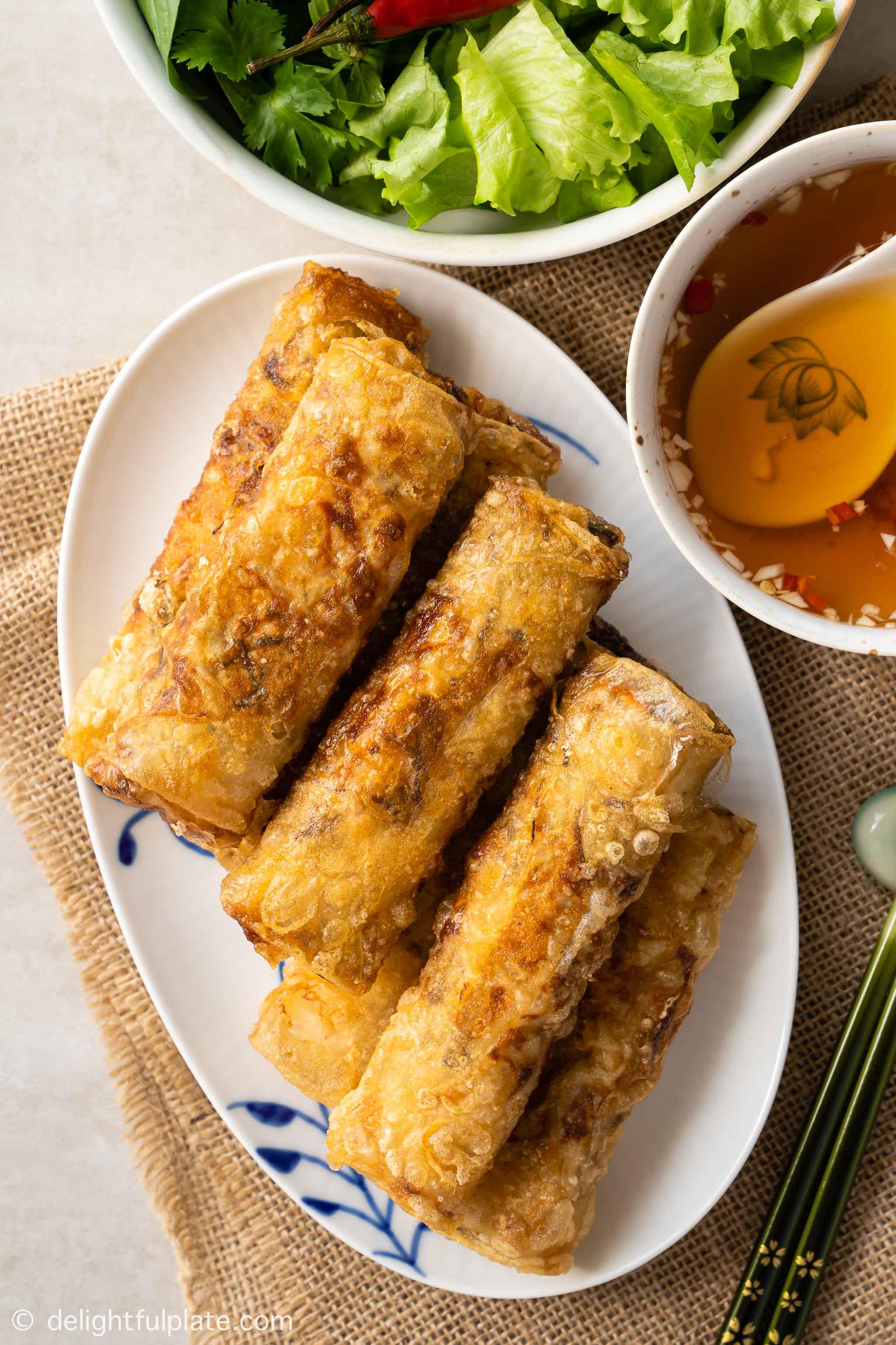 a plate of Vietnamese crispy spring rolls, served with dipping sauce